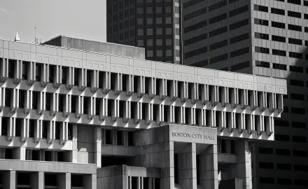 Black-and-white 4K Ultra HD PC desktop wallpaper of Boston, United States — Brutalist architecture: Boston City Hall's concrete geometric façade framed by shadowed office towers.