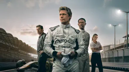 F1 (2025) HD PC desktop wallpaper — three racing team members in white suits stand on the pit lane beside an F1 car at dusk, with stadium lights and grandstands in the background.