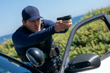 4K Ultra HD PC wallpaper: a uniformed police officer by a patrol car aiming a handgun, action scene from the movie Mercy (2026), featuring the film’s lead actor.