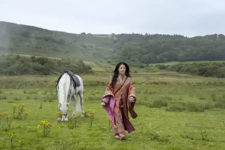 4K Ultra HD PC desktop wallpaper from the TV show Young Sherlock: a woman in a flowing pink robe walks across a green meadow beside a white horse with rolling hills under a pale sky.