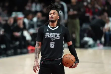 2K Quad HD PC desktop wallpaper of an NBA player in a San Antonio Spurs jersey holding a basketball on the court with arena crowd in the background.