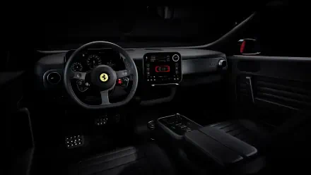 4K Ultra HD PC desktop wallpaper: dark Ferrari Luce interior—steering wheel with prancing horse emblem, dashboard, center console and pedals.