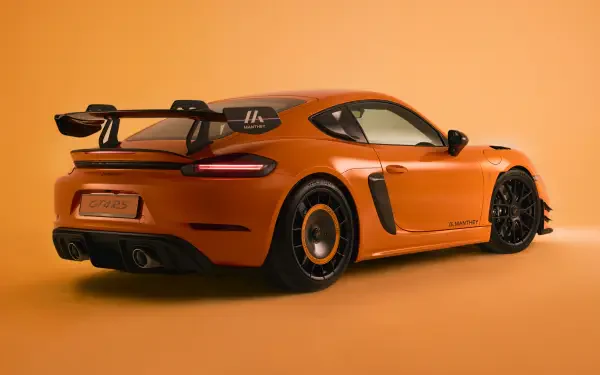 Orange Porsche 718 Cayman GT4, rear three-quarter view on a matching orange backdrop — 4K Ultra HD PC desktop wallpaper.