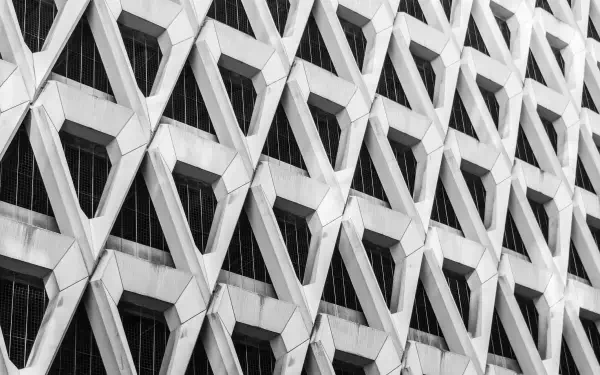 Monochrome close-up of Brutalist architecture facade with repeating geometric honeycomb pattern — architectural detail, HD PC desktop wallpaper and background.