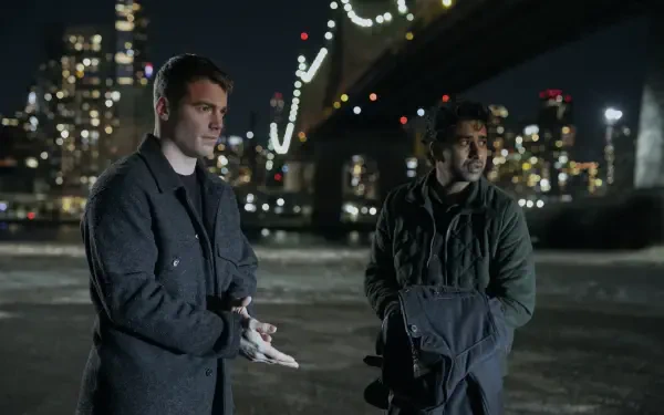 Thriller 2K Quad HD PC desktop wallpaper evoking The Night Agent: two men in coats converse beside a lit city bridge at night, tense waterfront skyline.