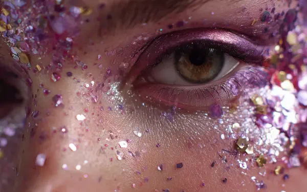 Close-up glam face with glitter-framed hazel eye and pink shadow, high-detail 2K Quad HD PC desktop wallpaper/background.