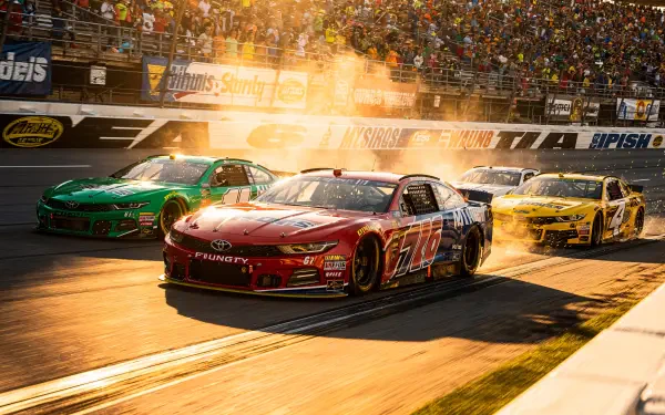 NASCAR race cars blasting past the finish line in warm sunset light, packed grandstands cheering — 4K Ultra HD PC desktop wallpaper/background.