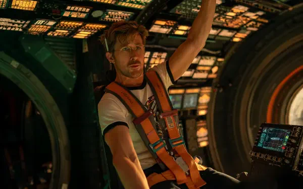 4K Ultra HD PC desktop wallpaper from the movie Project Hail Mary: astronaut in an orange harness reaches inside a glowing spacecraft cockpit.