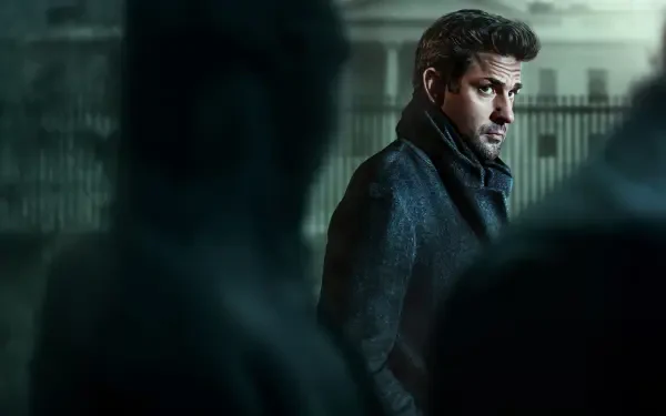 Jack Ryan in a moody, rain‑washed cityscape, glancing over his shoulder — 4K Ultra HD PC desktop wallpaper and background.