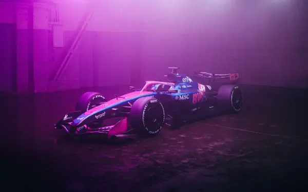 Pink Alpine F1 Team race vehicle parked in a moody garage, rendered as a 4K Ultra HD PC desktop wallpaper and background.