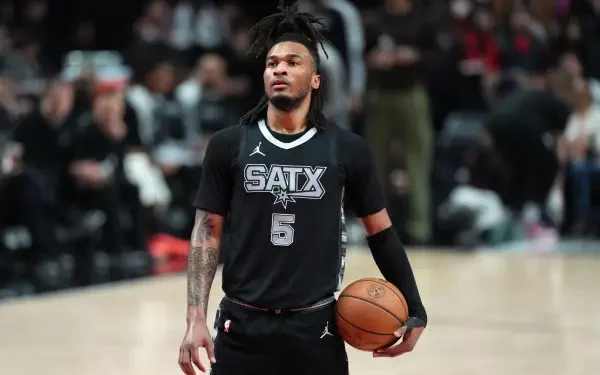 2K Quad HD PC desktop wallpaper of an NBA player in a San Antonio Spurs jersey holding a basketball on the court with arena crowd in the background.