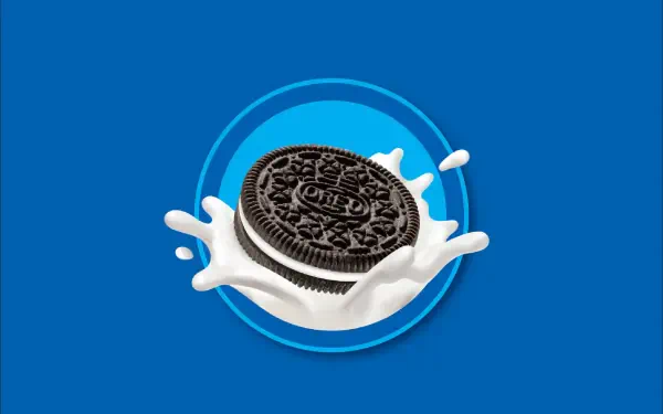 HD PC desktop wallpaper showing an Oreo cookie splashing into milk on a vivid blue background, a food-themed cookie image.