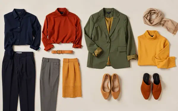 Capsule wardrobe flatlay of navy, rust, olive and mustard pieces with shoes and scarf — 4K Ultra HD PC desktop wallpaper background.