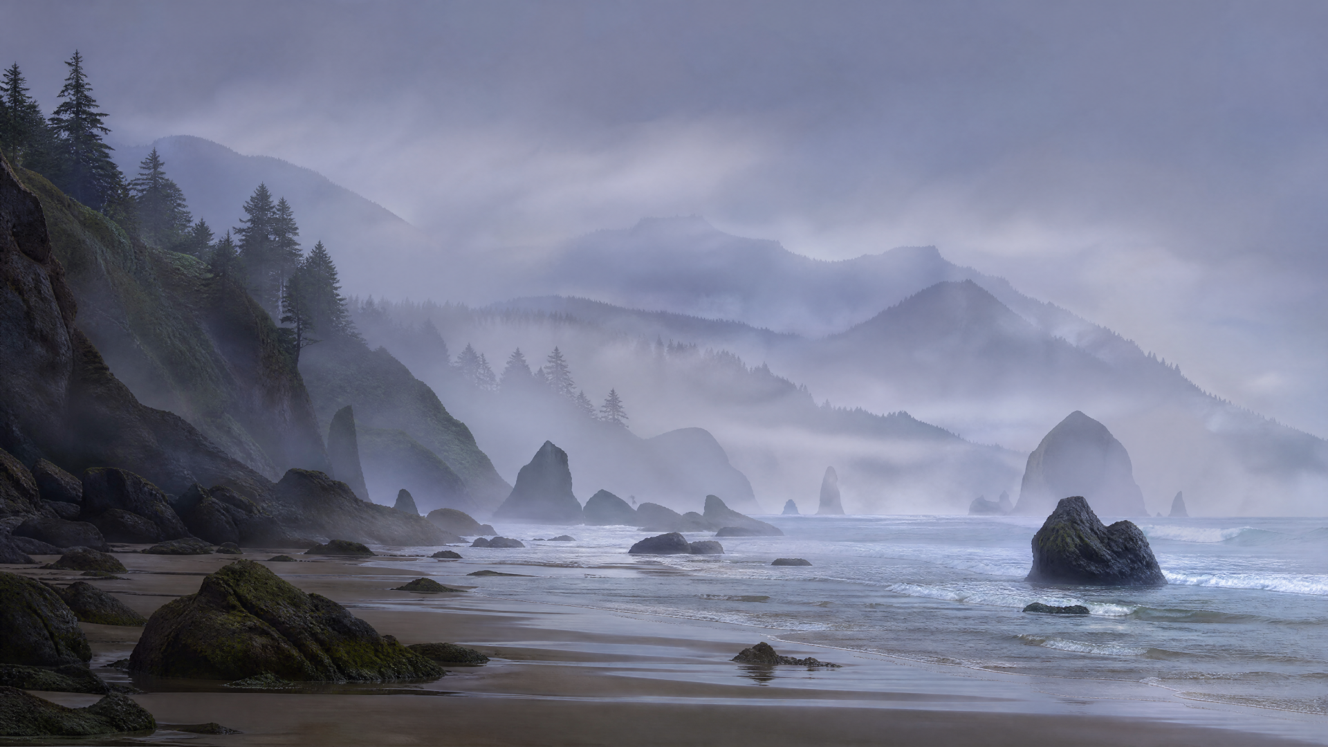 Misty seashore with rocky shoreline, waves and distant pine‑covered cliffs — 4K Ultra HD PC desktop wallpaper and background.