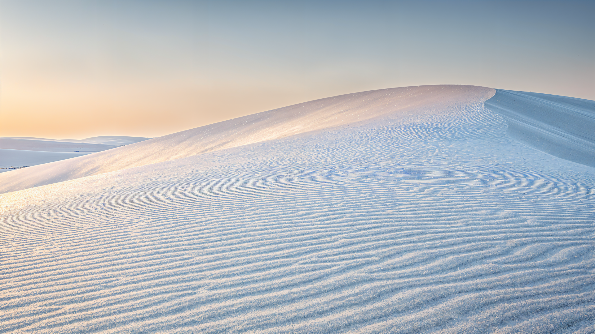Minimal sand dune at sunrise with rippled, wind-sculpted textures and a soft pastel sky — 4K Ultra HD PC desktop wallpaper background.