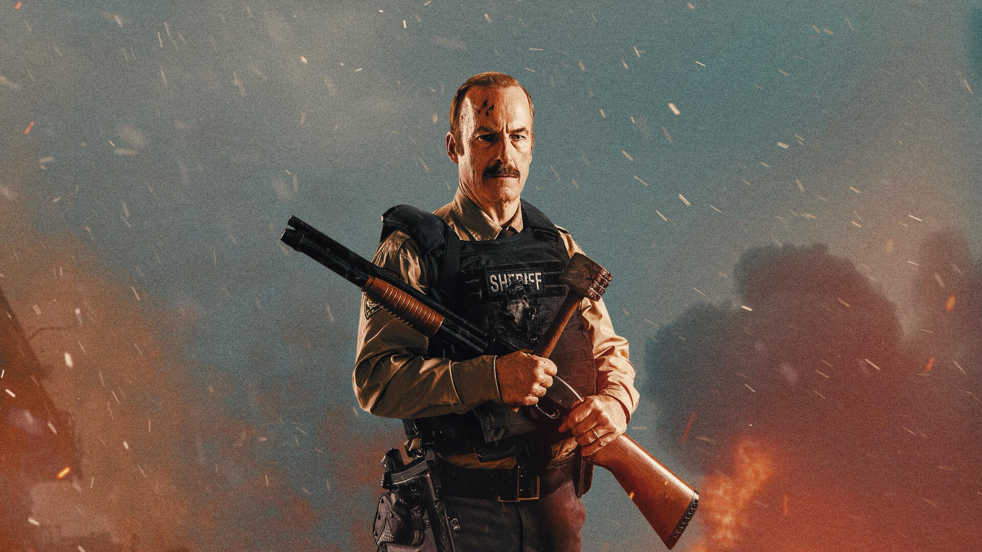 4K Ultra HD PC desktop wallpaper: a stern tactical officer in armored vest holds a shotgun across his chest amid smoky orange-blue battlefield lighting.