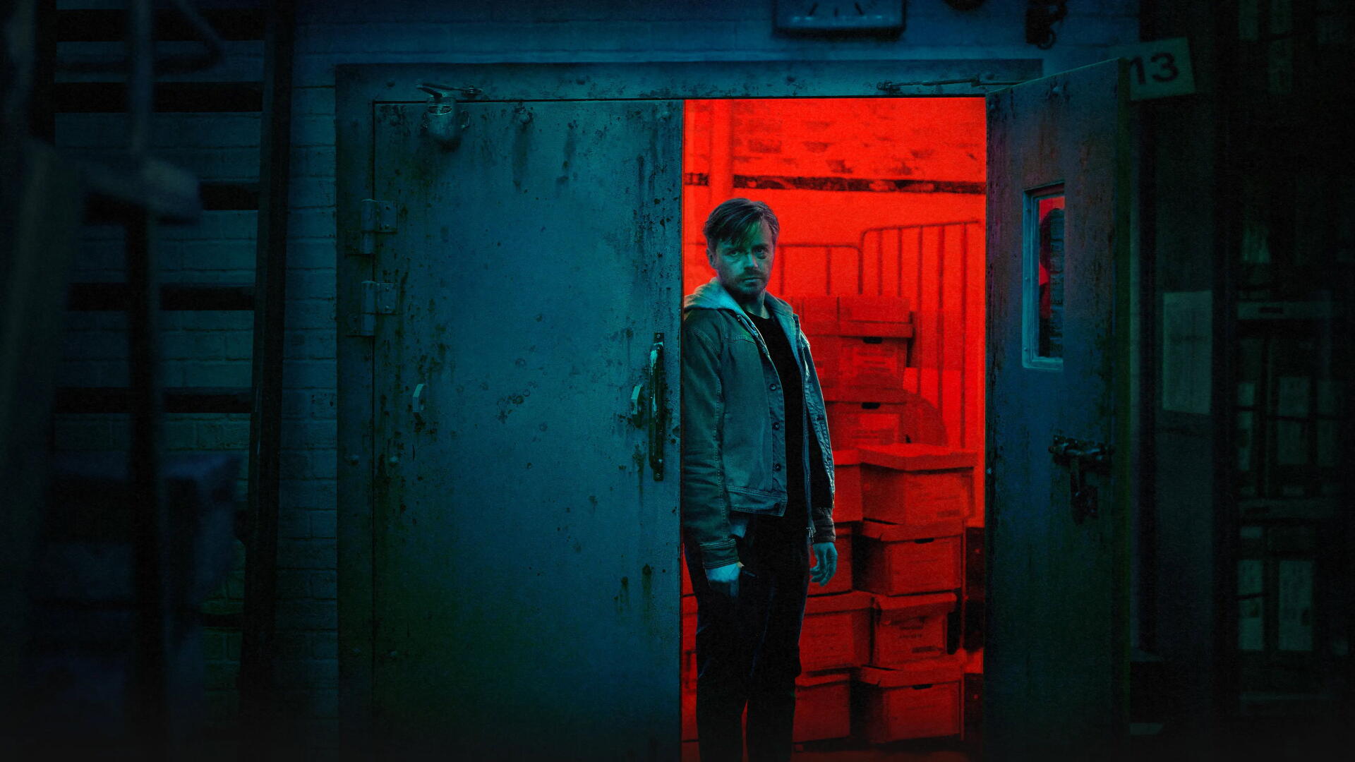 Slow Horses 4K Ultra HD PC desktop wallpaper: a solitary man stands in a red-lit doorway within a cool blue industrial room, moody cinematic atmosphere.