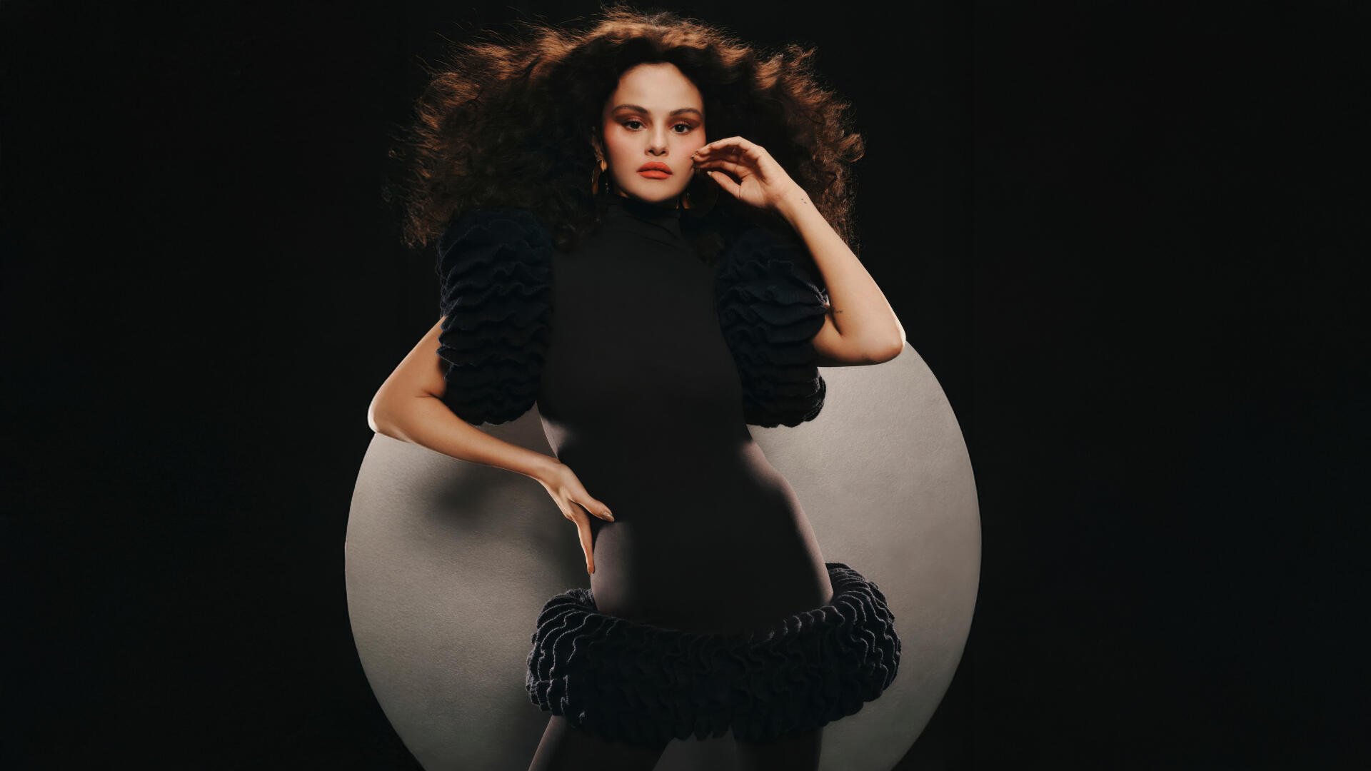 Glamorous female pop singer portrait in a dramatic black outfit with voluminous hair against a dark circular backdrop — 5K Ultra HD PC desktop wallpaper, celebrity music theme.
