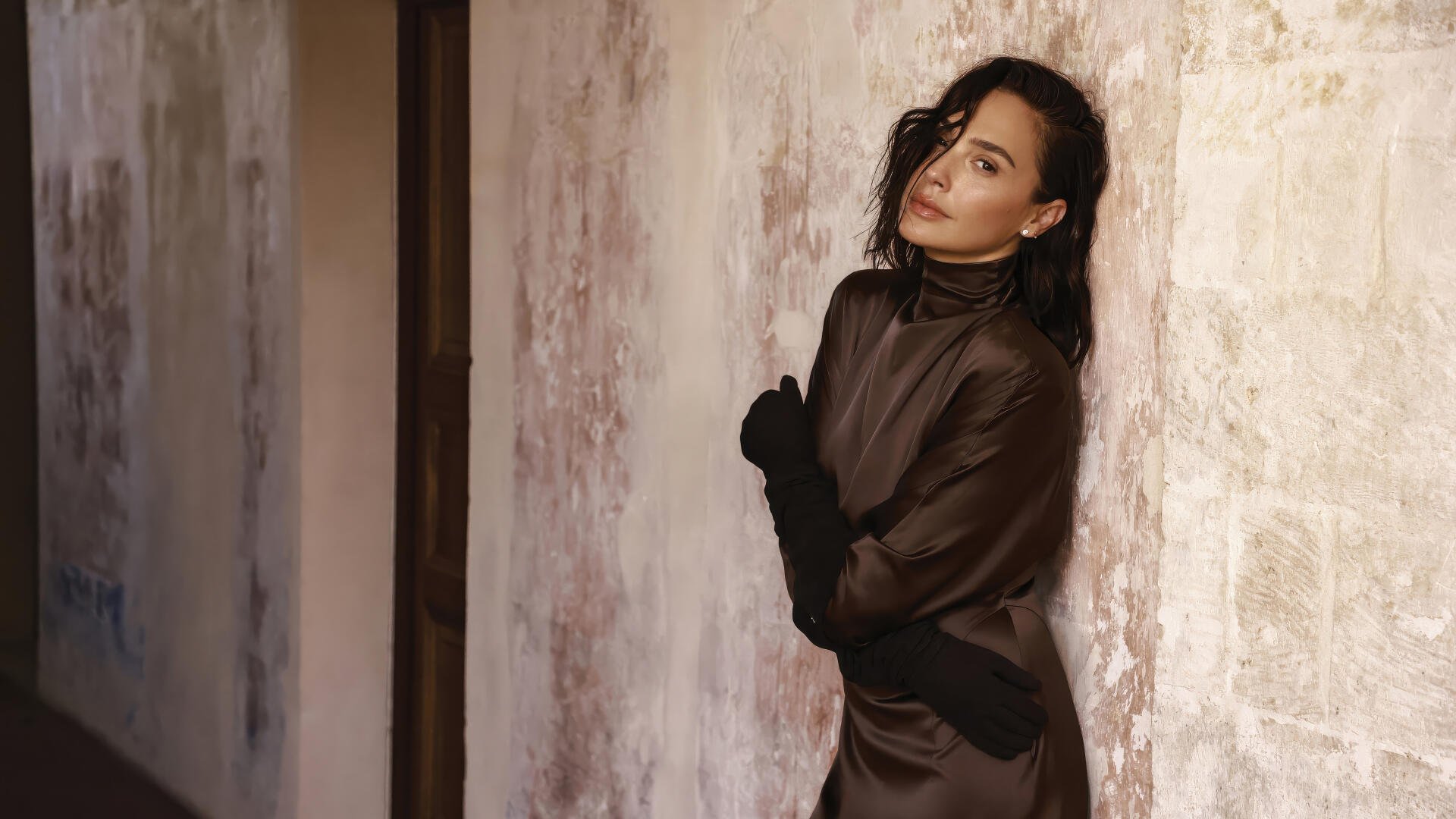 4K Ultra HD PC desktop wallpaper of an elegant woman in a dark satin gown leaning against a textured wall, evoking Hollywood actress glamour.