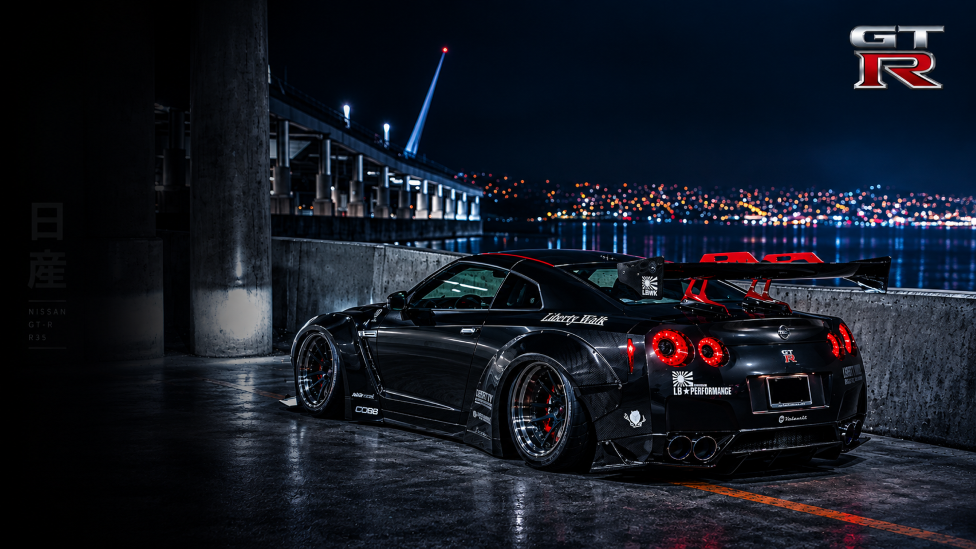 Black GTR-35 sports car by a waterfront at night, city lights reflecting on wet pavement — 2K Quad HD PC desktop wallpaper/background for computer.