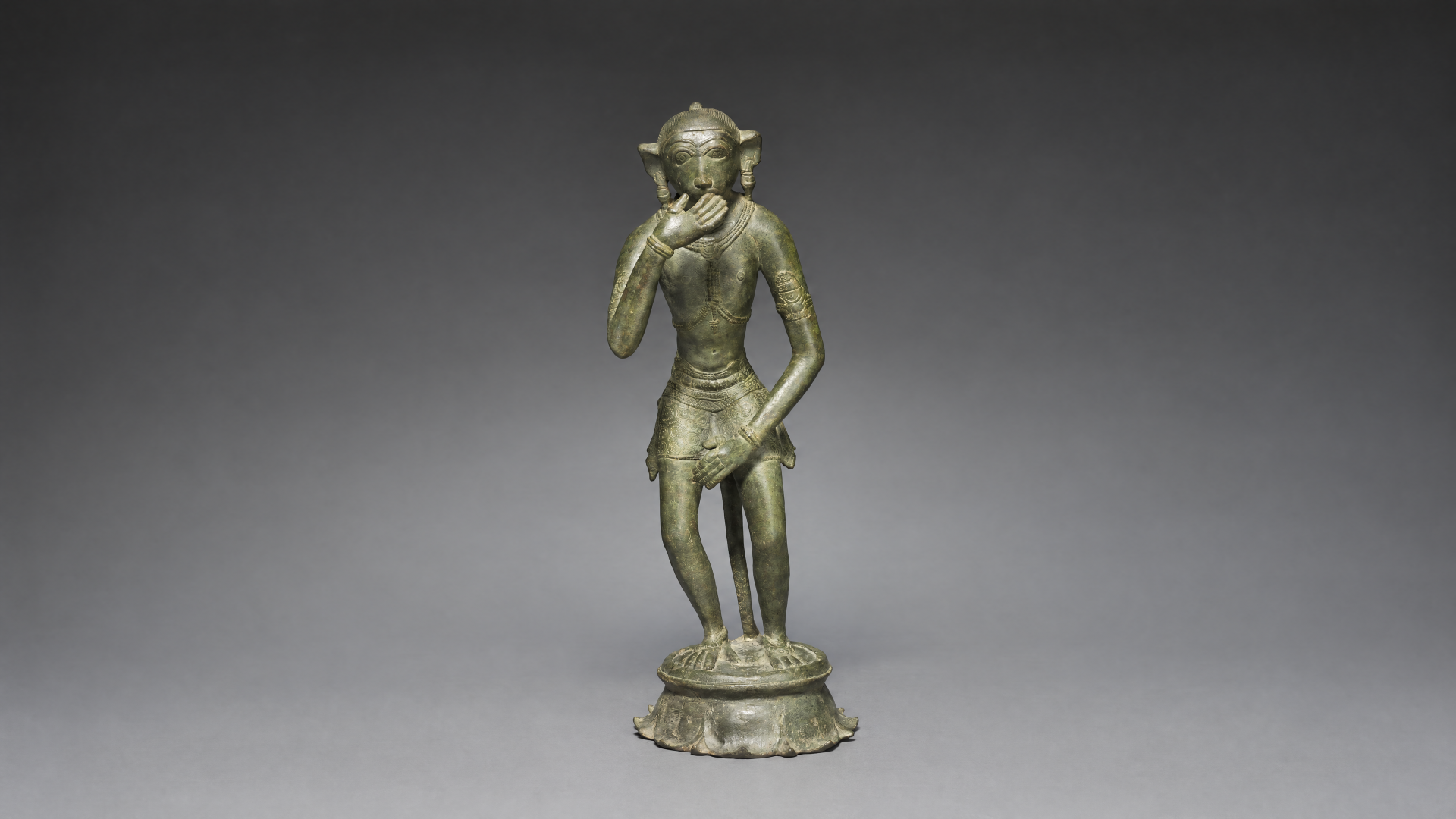 Bronze figurine statue of Lord Hanuman standing with one hand near his face on an ornate base, rendered as a 4K Ultra HD PC desktop wallpaper background.