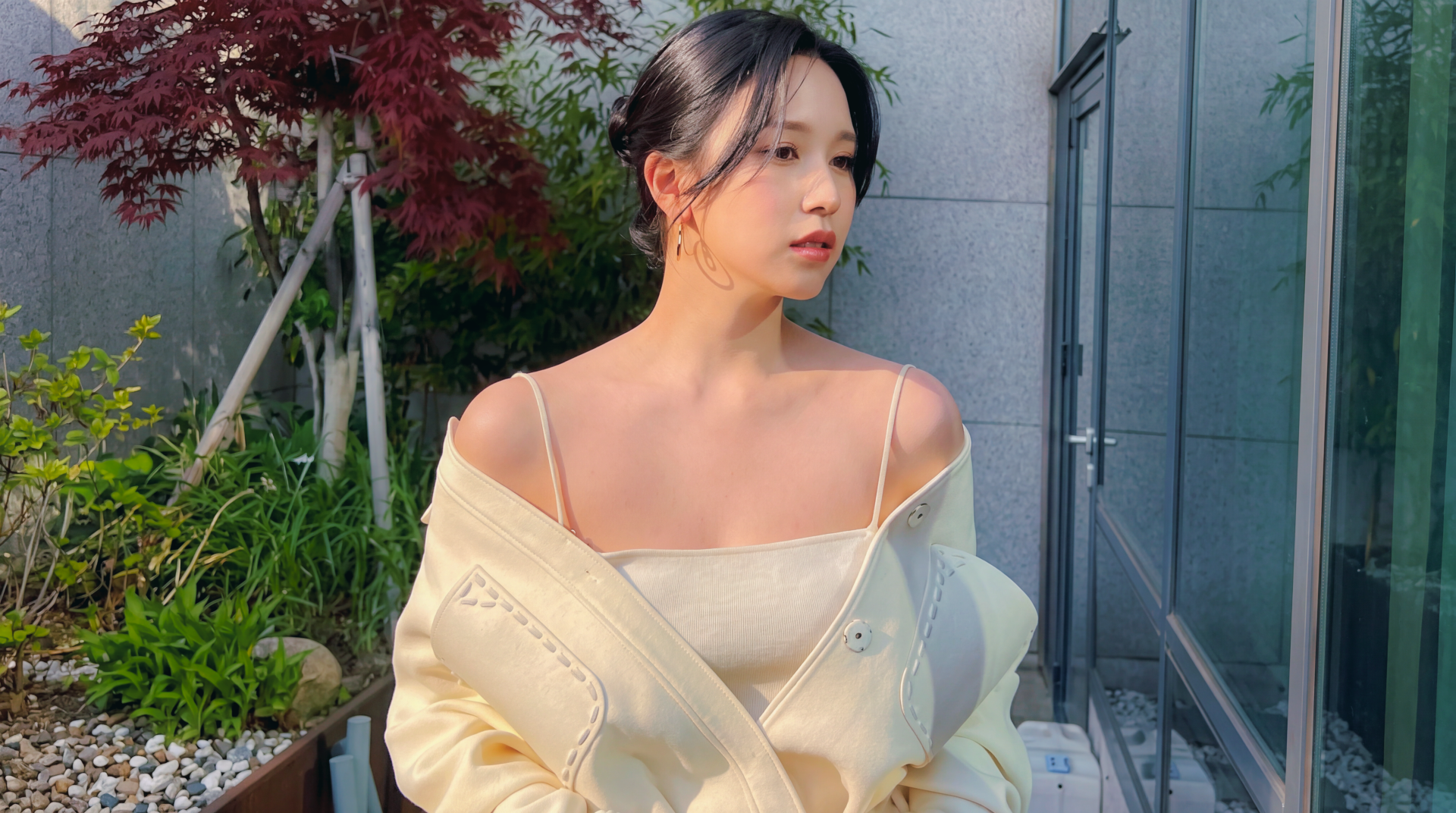 5K Ultra HD desktop wallpaper of a female singer-model styled like a K‑pop idol, wearing an off-white camisole and jacket while posing on a sunlit balcony.
