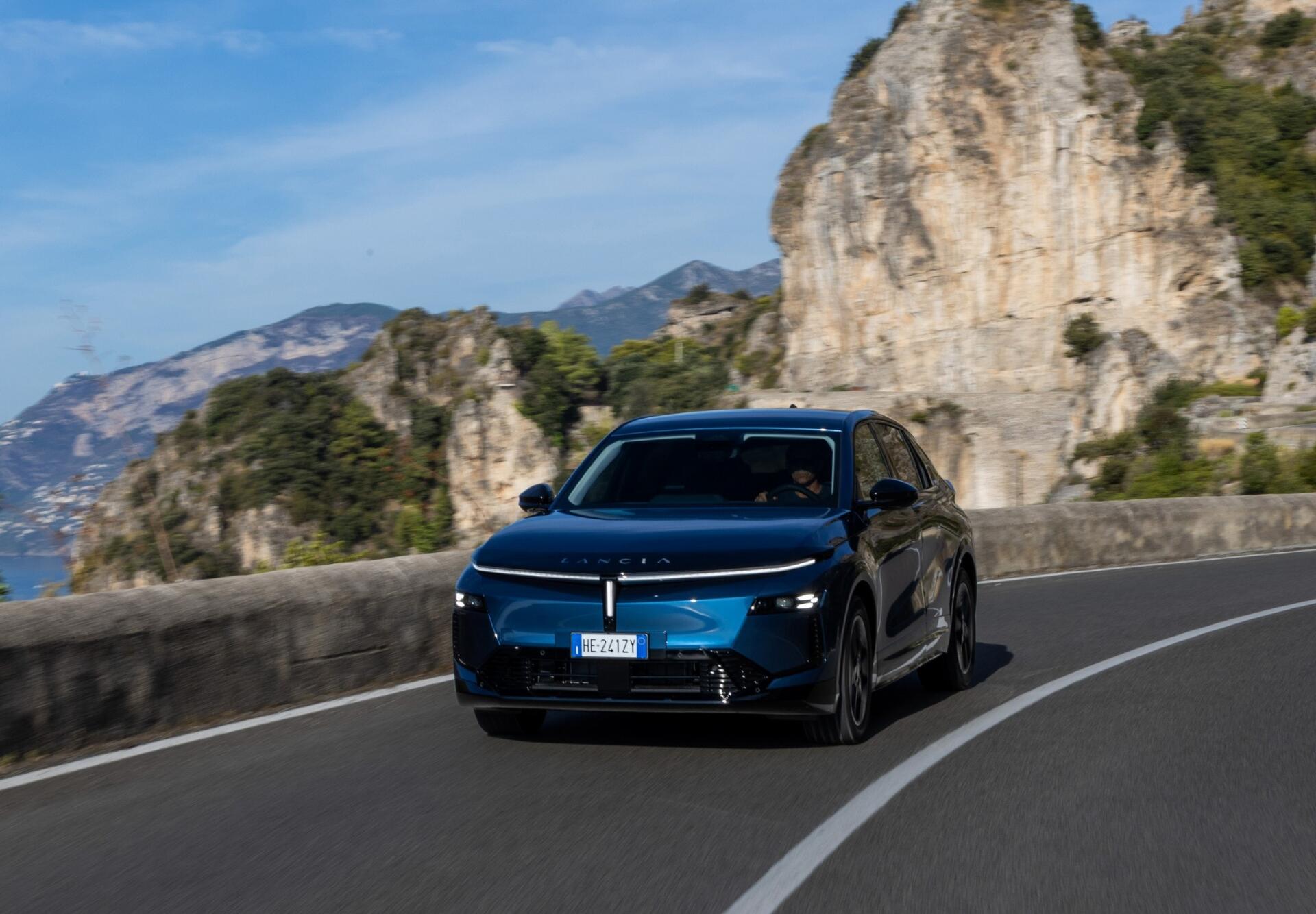 Lancia Gamma SUV driving along a scenic mountain road, featured in an HD PC desktop wallpaper and background.