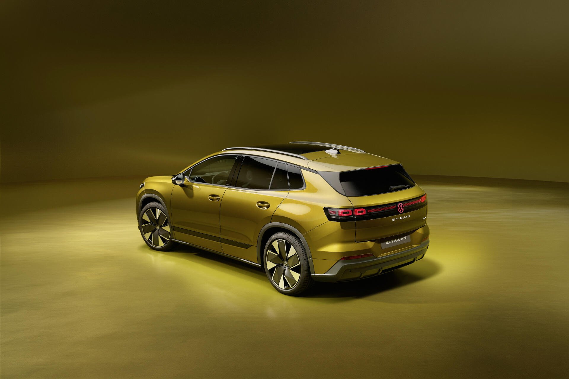 Volkswagen ID. Tiguan electric SUV in a golden studio scene, shown in a 4K Ultra HD desktop wallpaper background.