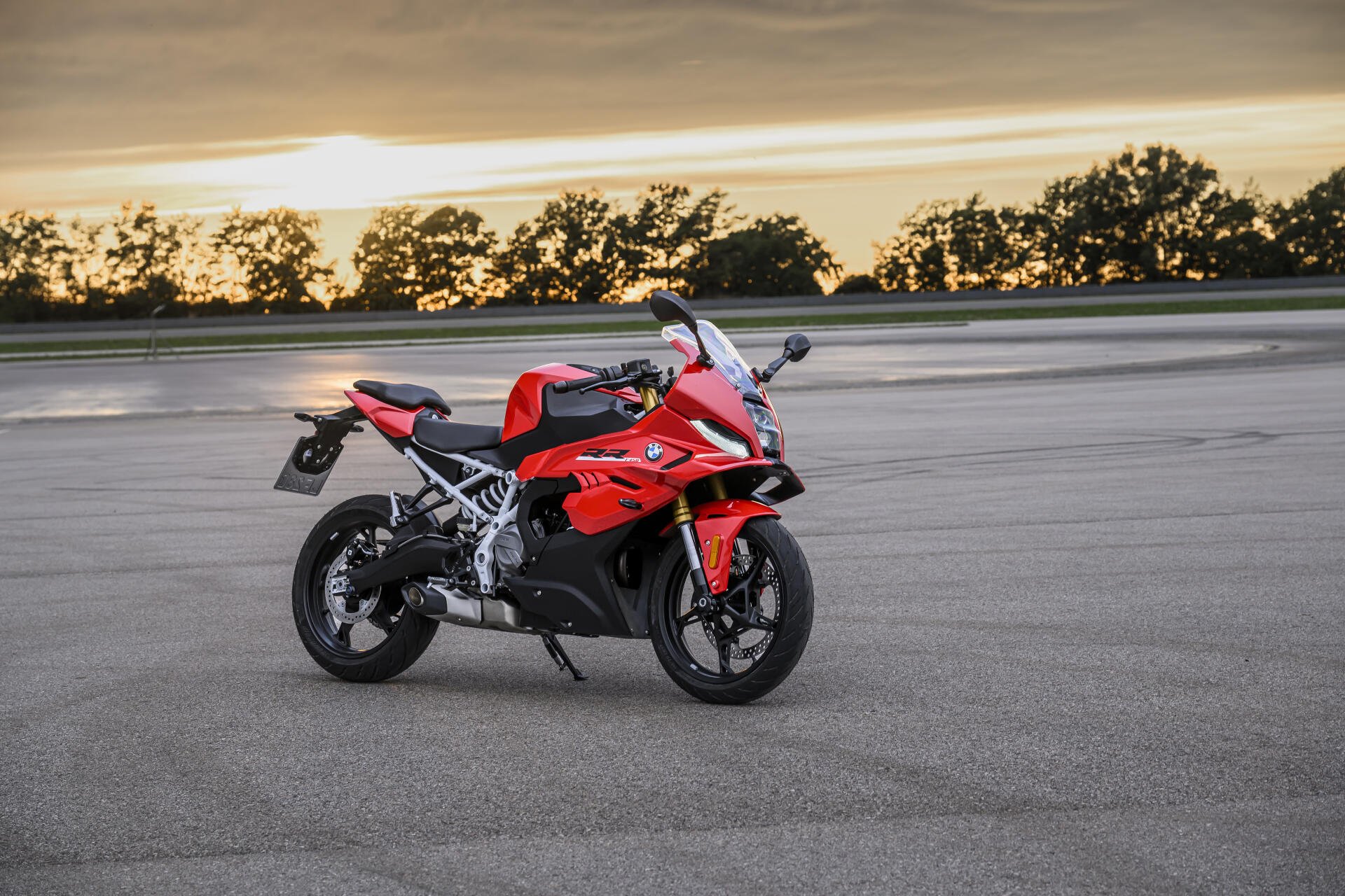 Red BMW F 450 RR sport bike on a paved track at sunset, featured in an 8K Ultra HD desktop wallpaper.