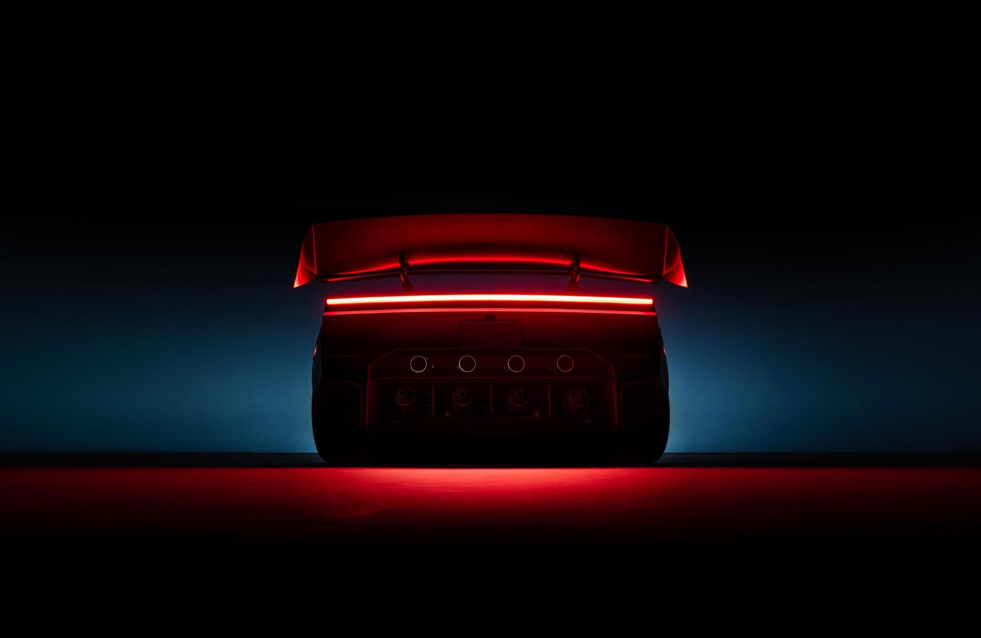 Tesla Roadster rear taillight glowing red in a dark scene, 2K Quad HD PC desktop wallpaper
