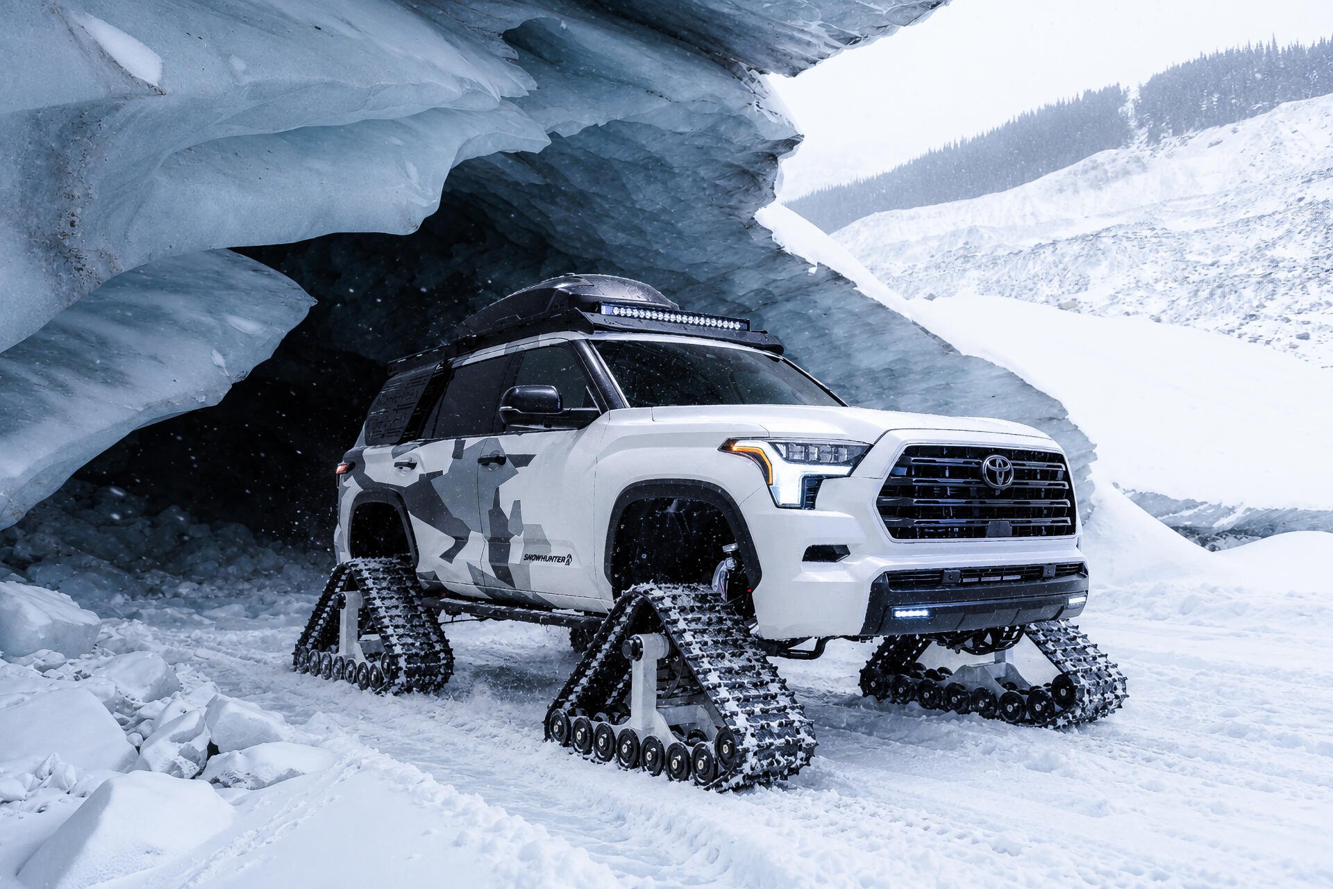 Toyota Sequoia Snowhunter with snow tracks beneath an icy overhang, shown in a 2K Quad HD PC desktop wallpaper.