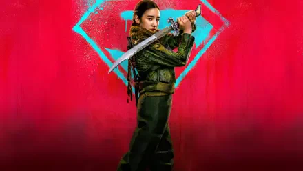 Supergirl (2026) 5K Ultra HD PC desktop wallpaper: a green‑suited Supergirl grips a sword before a glowing cyan S emblem set against a vivid red background.