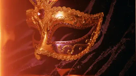 Gold filigree Mardi Gras mask with purple accents against dark, glittering bokeh — 4K Ultra HD PC desktop wallpaper background.