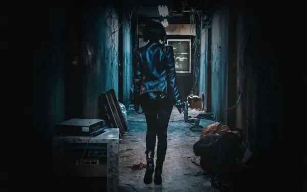 The Villainess — 4K Ultra HD PC wallpaper of a lone woman in a leather jacket walking down a dim, gritty corridor, pistol in hand toward a distant light.
