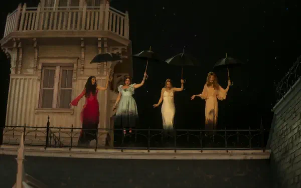 Practical Magic 2 wallpaper: four witches on a stage-like rooftop, women holding umbrellas against a starry night — 2K Quad HD PC desktop background.