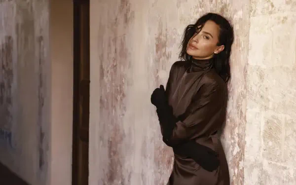 4K Ultra HD PC desktop wallpaper of an elegant woman in a dark satin gown leaning against a textured wall, evoking Hollywood actress glamour.