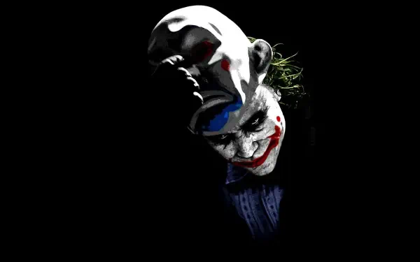 8K Ultra HD PC desktop wallpaper: Joker's painted grin and smeared red lips emerging from black, dark eyes and a faint suit in a moody, ominous composition.