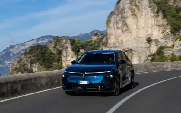 Lancia Gamma SUV driving along a scenic mountain road, featured in an HD PC desktop wallpaper and background.