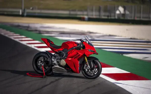Red Ducati Panigale V4 sport motorcycle on a race track, featured in an 8K Ultra HD PC desktop wallpaper.