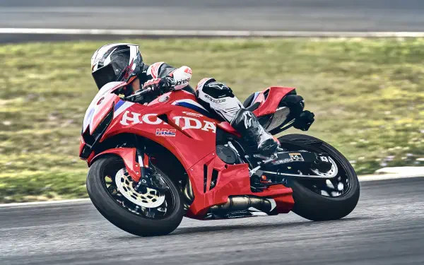 Honda CBR600RR racing motorcycle leaning through a track corner, featured in a 4K Ultra HD PC desktop wallpaper.