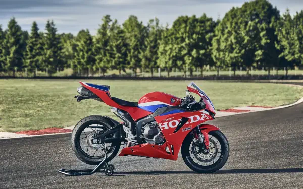 Red Honda CBR600RR sportbike on a racetrack, featured in a 4K Ultra HD PC desktop wallpaper and background.