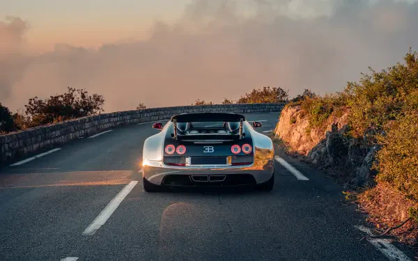 Bugatti Veyron Grand Sport Vitesse sports car driving along a scenic road at sunset, 5K Ultra HD PC desktop wallpaper and background.