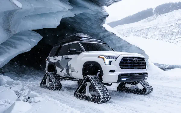 Toyota Sequoia Snowhunter with snow tracks beneath an icy overhang, shown in a 2K Quad HD PC desktop wallpaper.