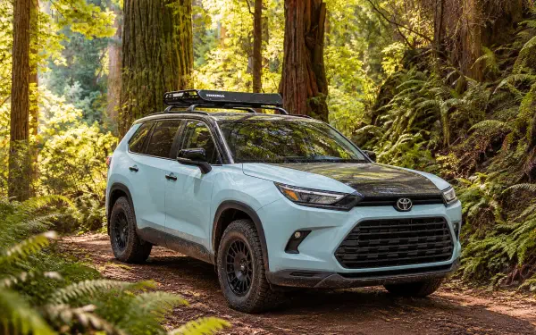 Toyota Grand Highlander Woodland Concept SUV on a forest trail, featured in a 2K Quad HD PC desktop wallpaper background.