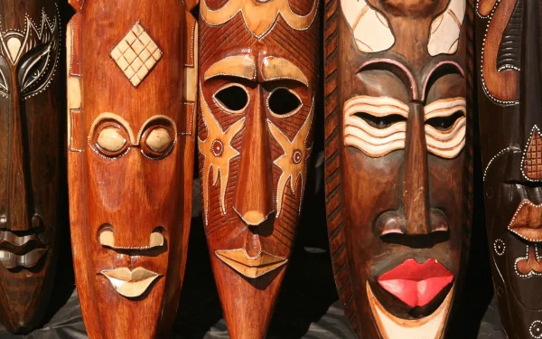 HD desktop wallpaper featuring detailed wooden African face carvings and masks, showcasing traditional craftsmanship and rich cultural artistry.