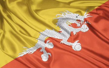HD PC desktop wallpaper of the flag of Bhutan: yellow (upper) and orange (lower) diagonal field with a white dragon clutching jewels, rippled silk texture.