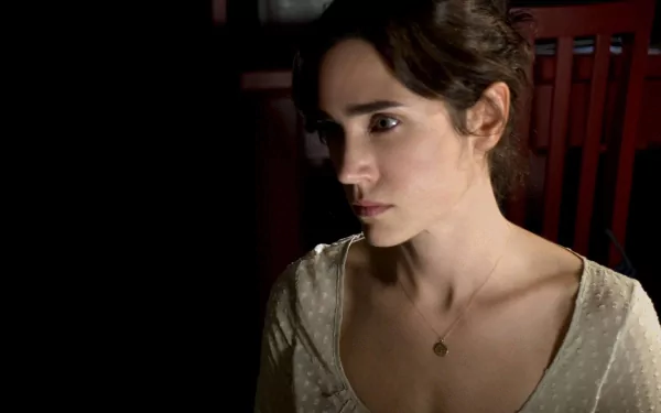 A captivating HD desktop wallpaper featuring actress Jennifer Connelly, showcasing her serene expression against a dark backdrop, highlighting her elegant features.