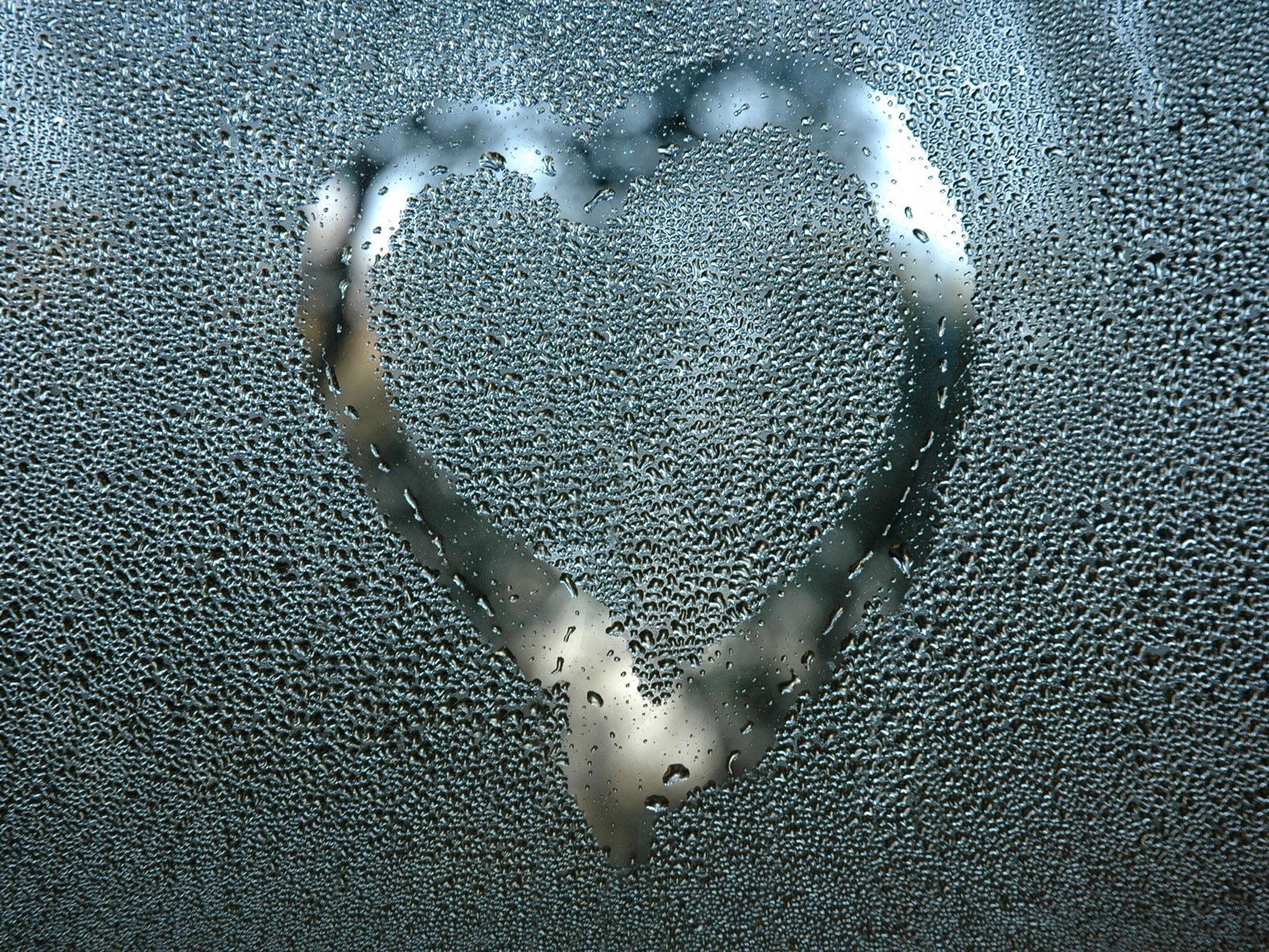 Artistic HD desktop wallpaper featuring a heart shape drawn on a fogged, water-droplet-covered surface, symbolizing love and emotion.
