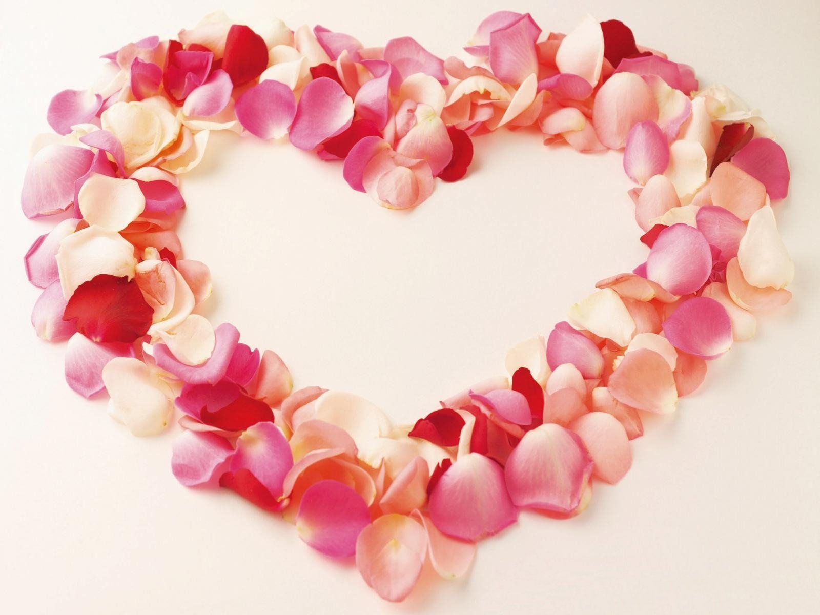 Artistic HD desktop wallpaper featuring a heart shape made of pink and red rose petals symbolizing love and romance.
