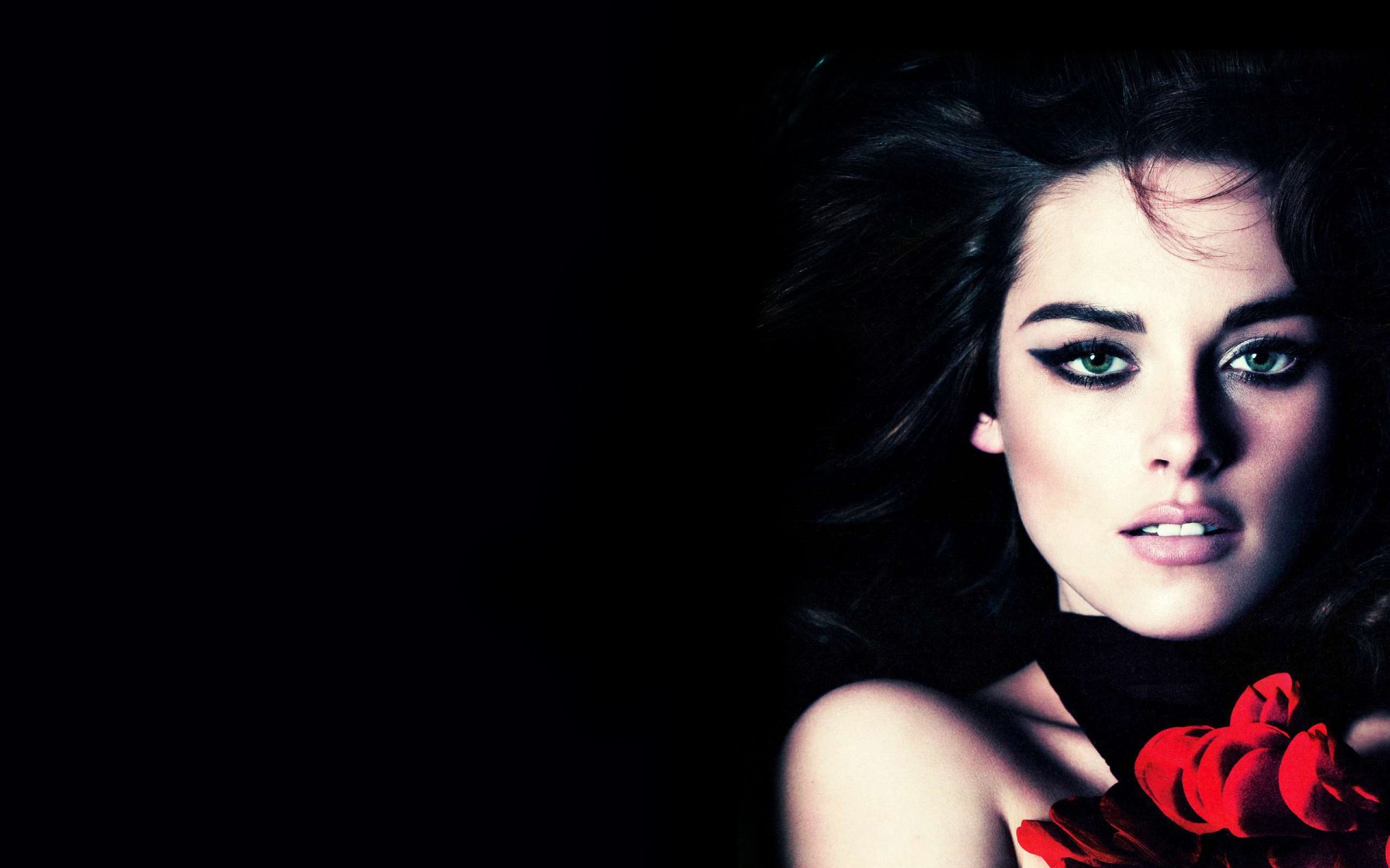 HD wallpaper featuring celebrity Kristen Stewart, showcasing her striking features with dramatic makeup and a bold floral accent against a dark background.